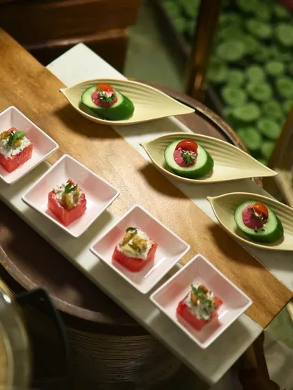 A beautiful arrangement of our watermelon and feta bites alongside cucumber and hummus canapés. The contrasting colours and shapes create a visually stunning platter.