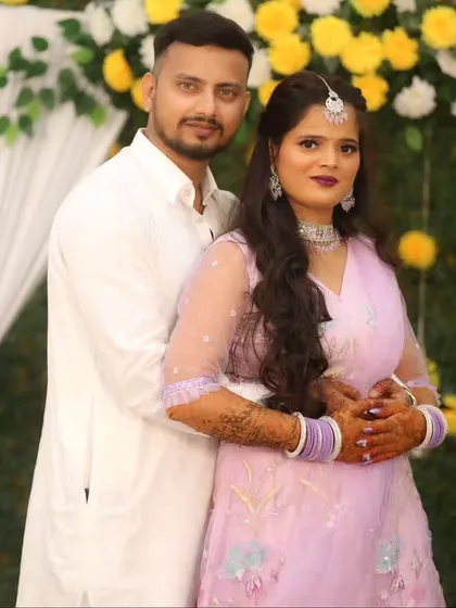 A classic couple portrait against a floral backdrop, perfect for an engagement or sangeet.