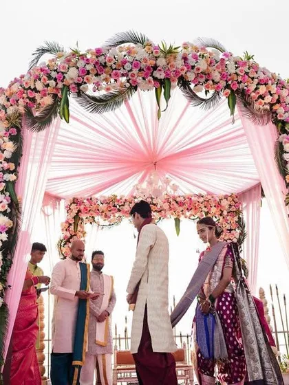 A beautiful rooftop mandap with a canopy of pink florals. This setup is perfect for a sunset wedding, offering a romantic ambiance and a stunning view.