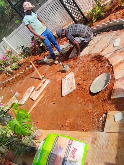 Our team at work, carefully placing stone pavers for a garden path. This hands on view shows the precision and effort that goes into every detail of our landscape construction projects.