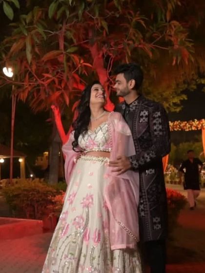 A magical moment captured. This couple is perfectly coordinated in a white and pink floral lehenga and a dark, subtly embroidered sherwani.