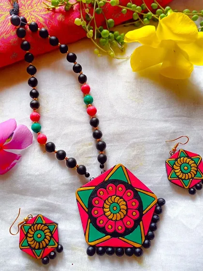 This version of the hexagonal pendant necklace uses a vibrant pink and green palette. It's a perfect accessory for adding a pop of color to any occasion.
