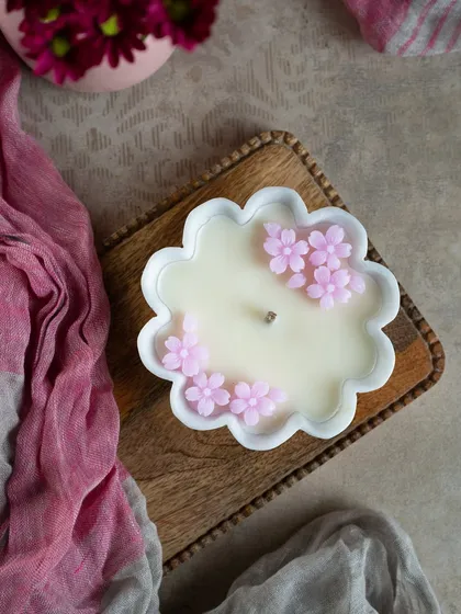 A delicate flower-shaped marble urli candle, this one is adorned with tiny pink wax flowers. It's a beautiful, handcrafted piece for your home.