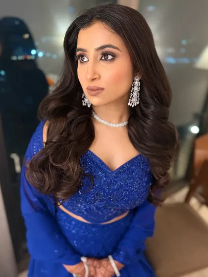 Another angle of this dazzling look. The bold eye makeup and flawless base create a stunning contrast with her vibrant blue lehenga.