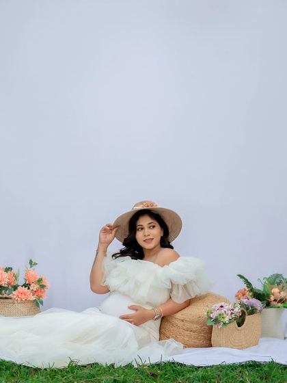 Adding a simple prop like a sun hat can completely change the feel of a photo. This shot feels like a peaceful picnic, a quiet moment of reflection for the mom-to-be.