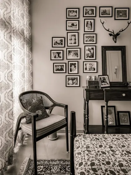 This corner of the 'Heritage Hue' bedroom is dedicated to memories, with a gallery wall of family photos and a vintage-style armchair.