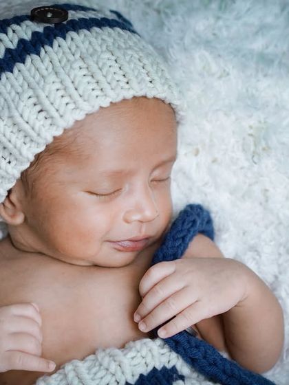 A sleepy smile from a tiny sailor. Even with a cute, themed outfit, a partial swaddle can help keep the baby calm and comfortable.