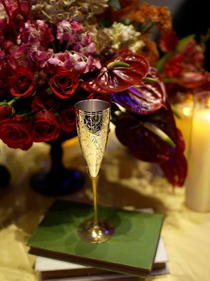 An ornate, gold-etched champagne flute, adding a touch of vintage glamour to the tablescape.
