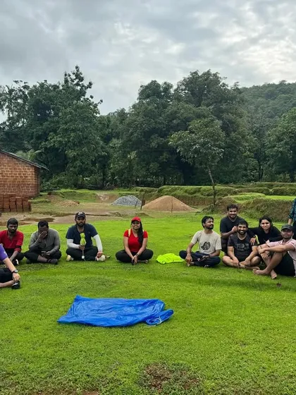 The group relaxing on the grass after a trek, enjoying the peaceful surroundings of a Malnad village.