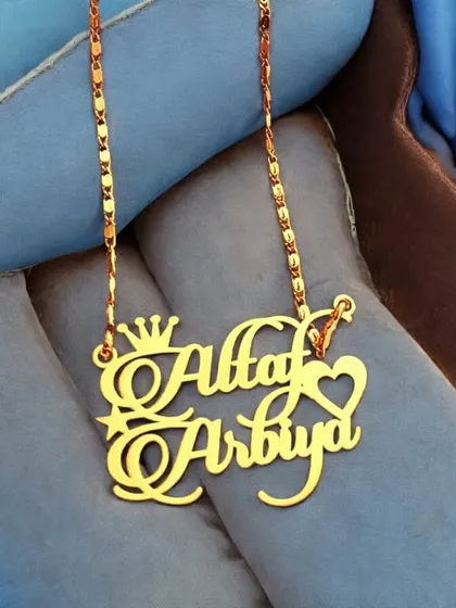 Perfect for couples, this custom pendant displays two names in a beautiful script, accented with a crown and a heart. The gold-plated finish gives it a rich and celebratory look.