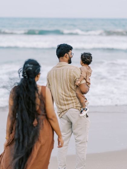 A family looking out at the ocean. The vastness of the sea provides a stunning and dramatic backdrop for a family portrait.