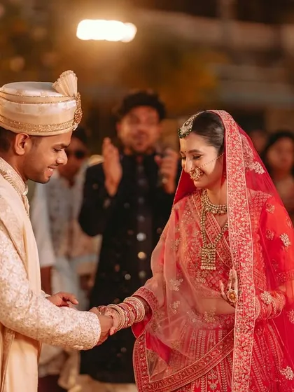 The groom takes the bride's hand, a gesture of partnership and love, as they begin their new life together.
