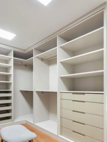 Another angle of the walk-in closet framework. The L-shaped design makes full use of the corner, providing extensive shelving and hanging space tailored to the client's needs.