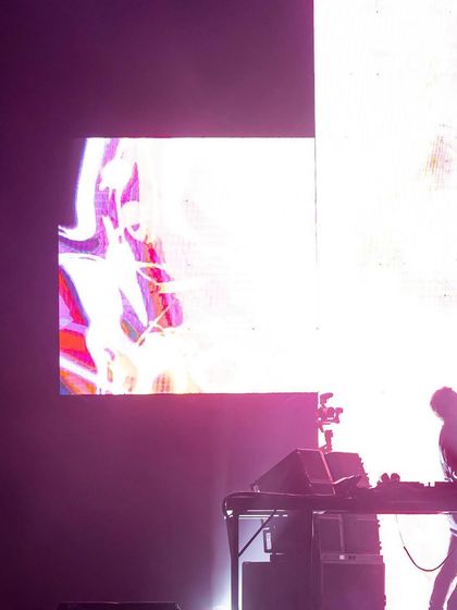 A silhouette of Martin Garrix against a bright screen, a classic concert shot that captures the energy of the performer.