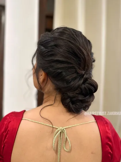 A textured, messy bun with a central braid. This style is perfect for someone who wants a relaxed yet elegant updo for a party or pre-wedding event.