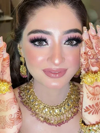 A close-up of her stunning makeup, showing off the beautiful pink-toned eyeshadow and her intricate henna design.
