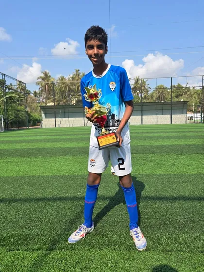 A member of the U14 Feugo Lions team with his championship trophy.