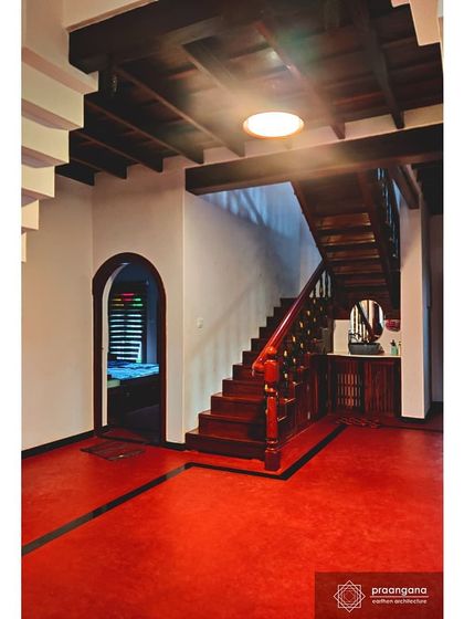The staircase and red oxide flooring in our Udupi project. The vibrant, polished red floor is a signature of traditional South Indian homes, known for its cooling properties and durability.