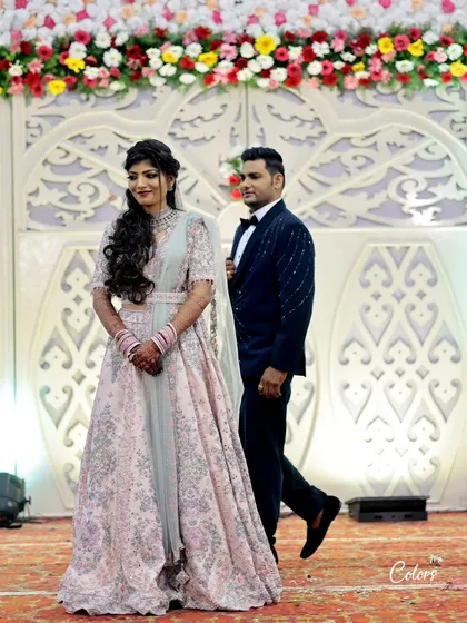 The groom walks his bride onto the reception stage, ready to begin the night's celebrations.
