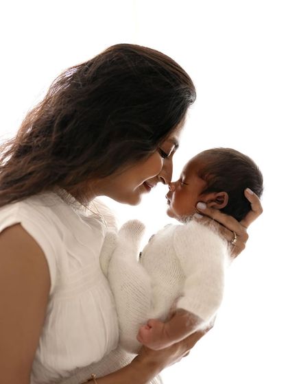 A mother and her newborn, nose to nose. This simple, high-key portrait is all about the pure love and connection between them.