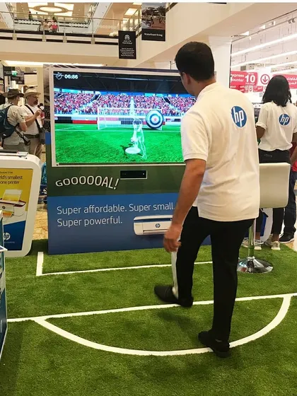 Here is our motion-sensing soccer game in action at an HP brand activation. Participants kick a real ball towards a large screen, where sensors track its speed and trajectory for a fun and competitive penalty shootout experience that draws a crowd.
