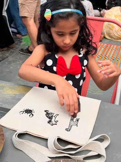 Concentration and creativity in action! This child is choosing her next animal block to add to her tote bag design, learning about different species as she creates her own sustainable bag.