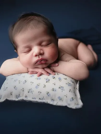 Sometimes, the simplest portraits are the most powerful. My minimalist style focuses entirely on your baby's sweet features. This classic beanbag pose shows off those adorable chubby cheeks and peaceful sleep.