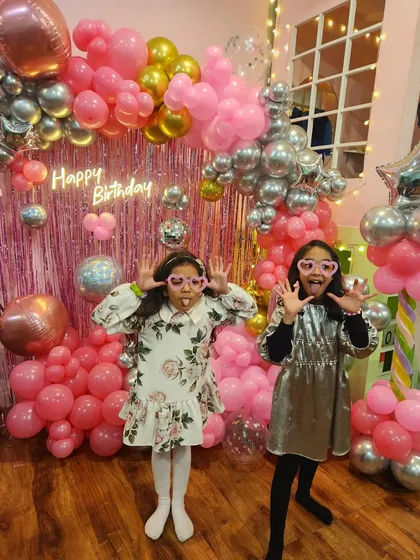 Just some monkey business! Two girls making funny faces for the camera in front of the popstar backdrop.