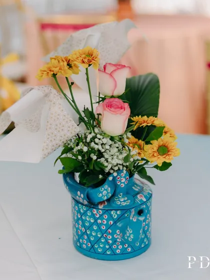A quirky and cute centerpiece for a Mehendi, using a hand-painted blue elephant teapot as a vase for a small floral arrangement.