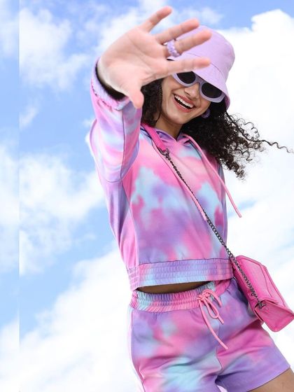 A dreamy, creative shot against a sky backdrop. I styled this pastel tie-dye co-ord set with a matching bucket hat and sunglasses for a fun, whimsical look that feels light and airy.