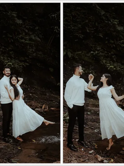 A couple enjoying a playful moment by a stream. The matching white outfits stand out beautifully against the dark, natural background of the woods.
