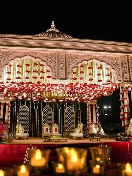 We honor tradition with grandeur. This magnificent wedding stage was inspired by temple architecture, featuring intricate domes, a canopy of red roses, and rich fabrics to create a sacred and royal ambiance.