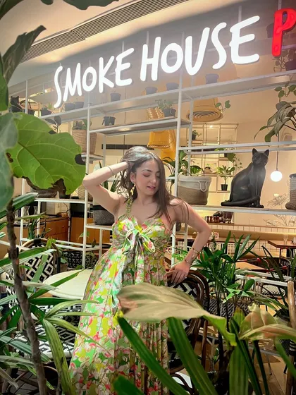 Posing outside Smoke House Deli, surrounded by its signature green plants, which makes for a great photo opportunity.
