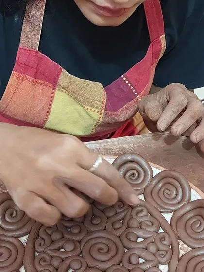 A student carefully places coiled spirals onto her platter, creating a beautiful, textured design. This coiling technique is versatile and allows for so much creativity, and it's one of the first things I teach in my hand-building workshops.