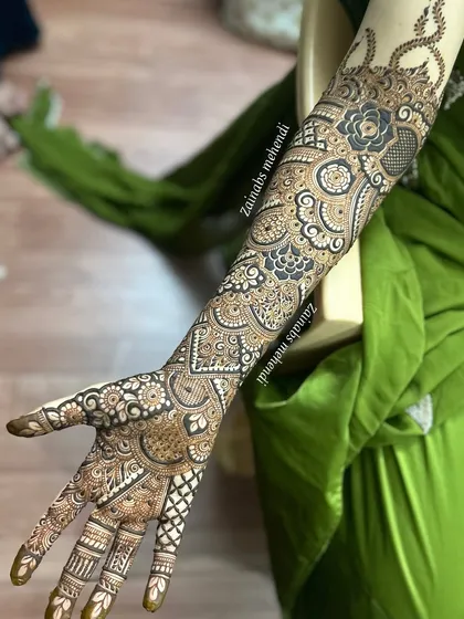 A full arm design for bride Leena, combining bold floral elements with delicate, intricate fillers.