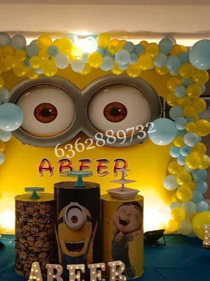A fun Minion theme for a 7th birthday, with the iconic goggle eyes as the central backdrop feature and character-themed cake stands.
