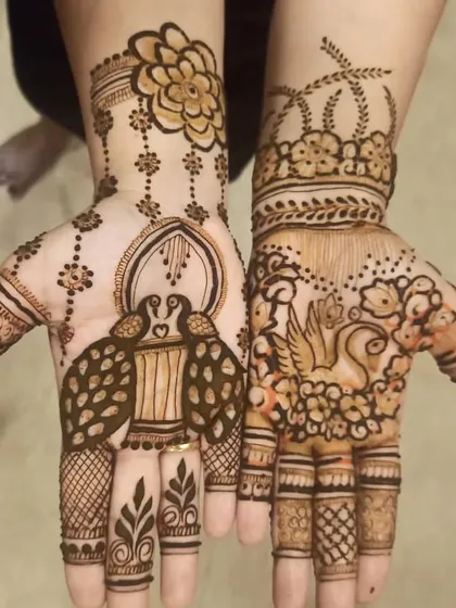 A modern and artistic take on traditional motifs. One hand features a peacock in a jharokha (window), while the other has a swan, offering a unique and creative mehndi style.