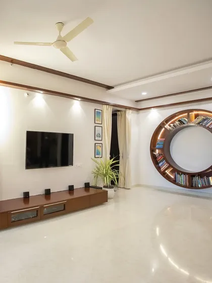A home should have elements that are uniquely you. This living room features a stunning custom-designed circular bookshelf with integrated lighting, turning a simple wall into a functional work of art and a true conversation starter.