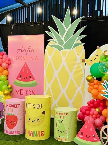 Aafia is 'One in a Melon'. This vibrant, fruit-themed party featured giant pineapple and watermelon cutouts, along with fun, character-faced fruit props and a colorful balloon garland.