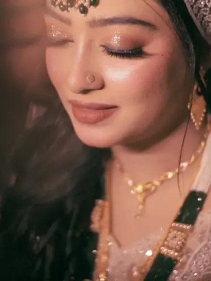 A close-up bridal portrait that highlights the bride's stunning makeup and the sparkle of her wedding lehenga. The soft lighting accentuates her features and the quiet joy of the moment.