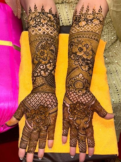 A beautiful full bridal mehendi with a mix of floral and geometric patterns. The design is symmetrical and provides excellent coverage.