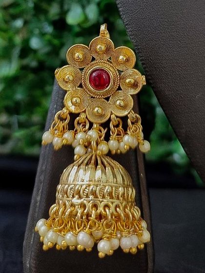 A delicate gold-finish jhumka with a floral top and pearl drops.