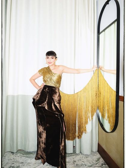 A full-length view of the gold and brown velvet outfit. The fringe detail on the mirror was part of the event's art direction, and we used it to create a dynamic composition.