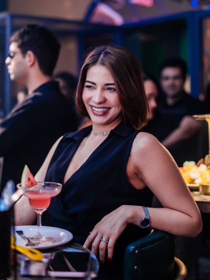 A smile and a cocktail, the perfect combination for a great night out. The atmosphere is relaxed and fun.
