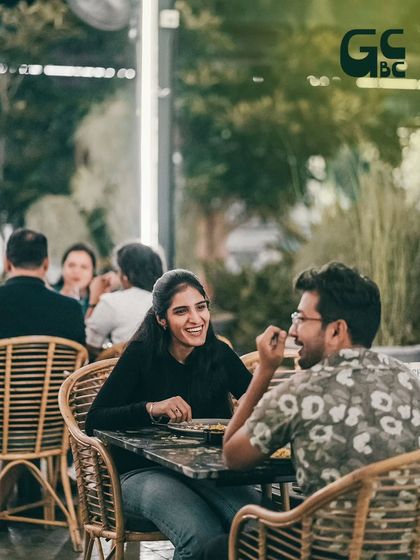A candid moment of laughter and conversation between a couple enjoying their meal.