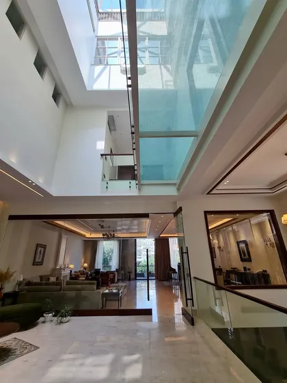 This home is defined by its clean geometry and double height spaces. A glass bridge overhead allows light to flood the lower level, creating a seamless integration of open spaces.