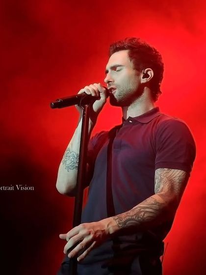 A close-up of Adam Levine singing under intense red lighting. This shot focuses on the emotion and passion of the performance, a key element I always look for in my concert photography.