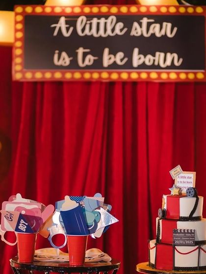 A close-up of the themed dessert table, featuring a custom cake and fun photo props. Every detail, from the 'A little star is to be born' sign to the cake, is designed to match the movie premiere theme.