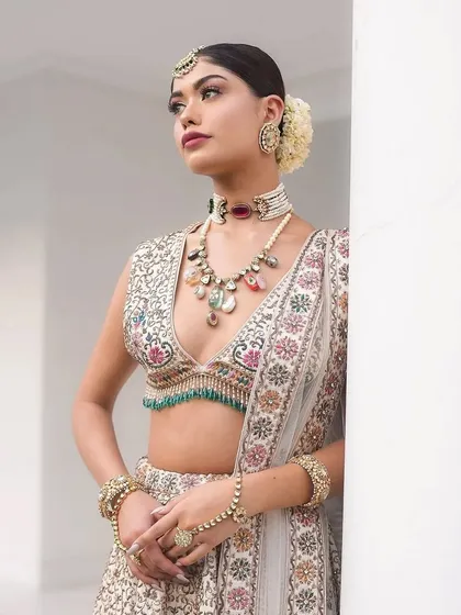 A close-up of the "Laila" look. The styling focuses on the unique, multi-gemstone necklace that complements the embroidery on the blouse.