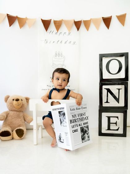 This little guy is reading all about it. A playful portrait with the "My First Birthday" newspaper prop, adding a unique touch to the session.